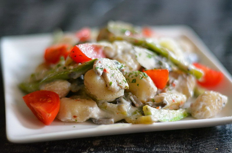 Gnocchi with mushroom, tomato, and zucchini in a creamy sauce